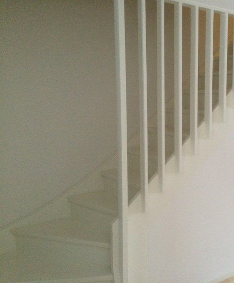 Ny hvit trapp med spilerekkverk og lys eikeparkett etter renovering
